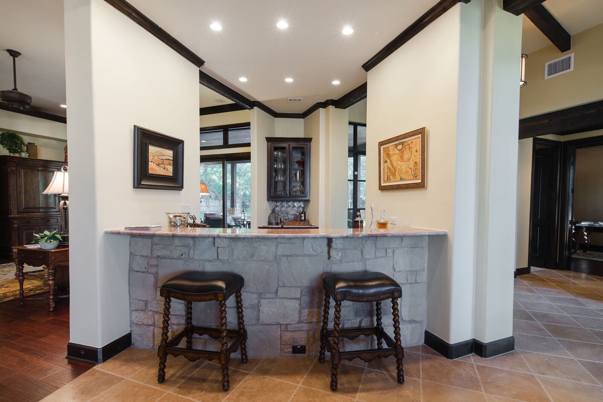 Stone-accented home bar in a custom home by J Bryant Boyd in Georgetown, TX