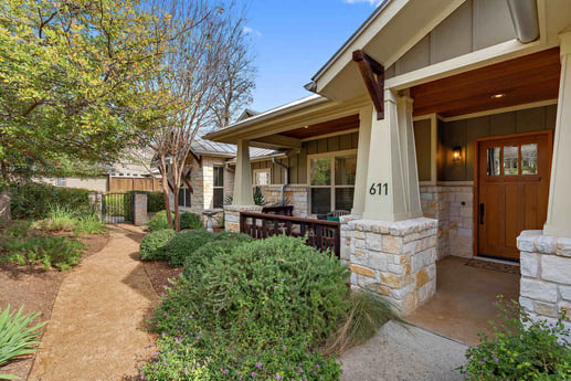 Front entrance of a stone custom home with a landscaped walkway, by J Bryant Boyd in Georgetown, TX