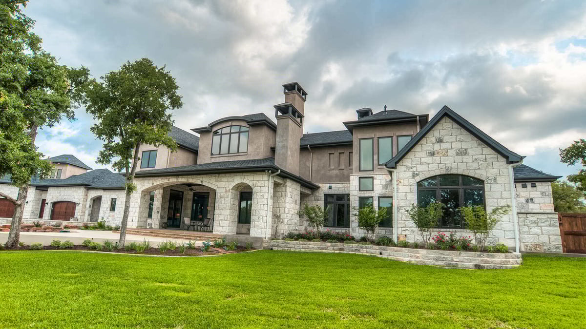 Front lawn and stone exterior of a custom luxury home in Georgetown, TX by J Bryant Boyd