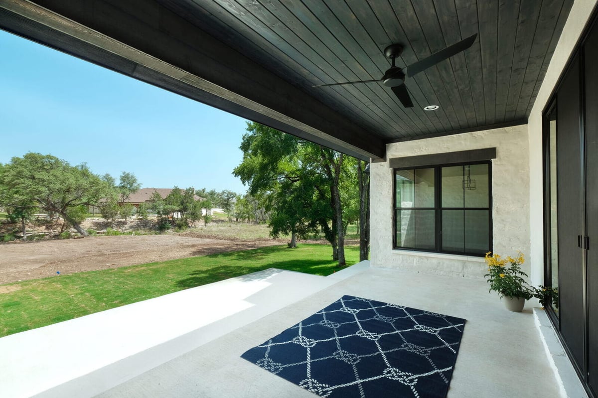 Backyard patio with a view of the lawn by J Bryant Boyd in Georgetown, Texas