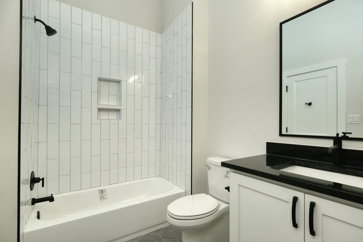 Spacious bathroom with large vanity and mirror by J Bryant Boyd in Georgetown, Texas
