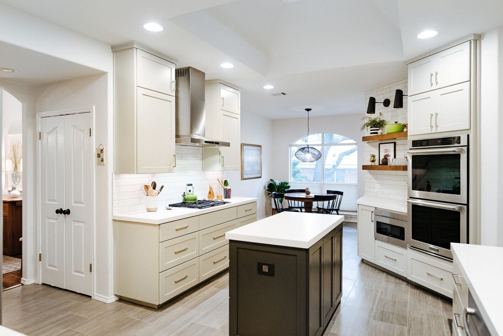Full view of a remodeled kitchen and dining area by J Bryant Boyd in Georgetown, Texas with an island and stainless steel appliances