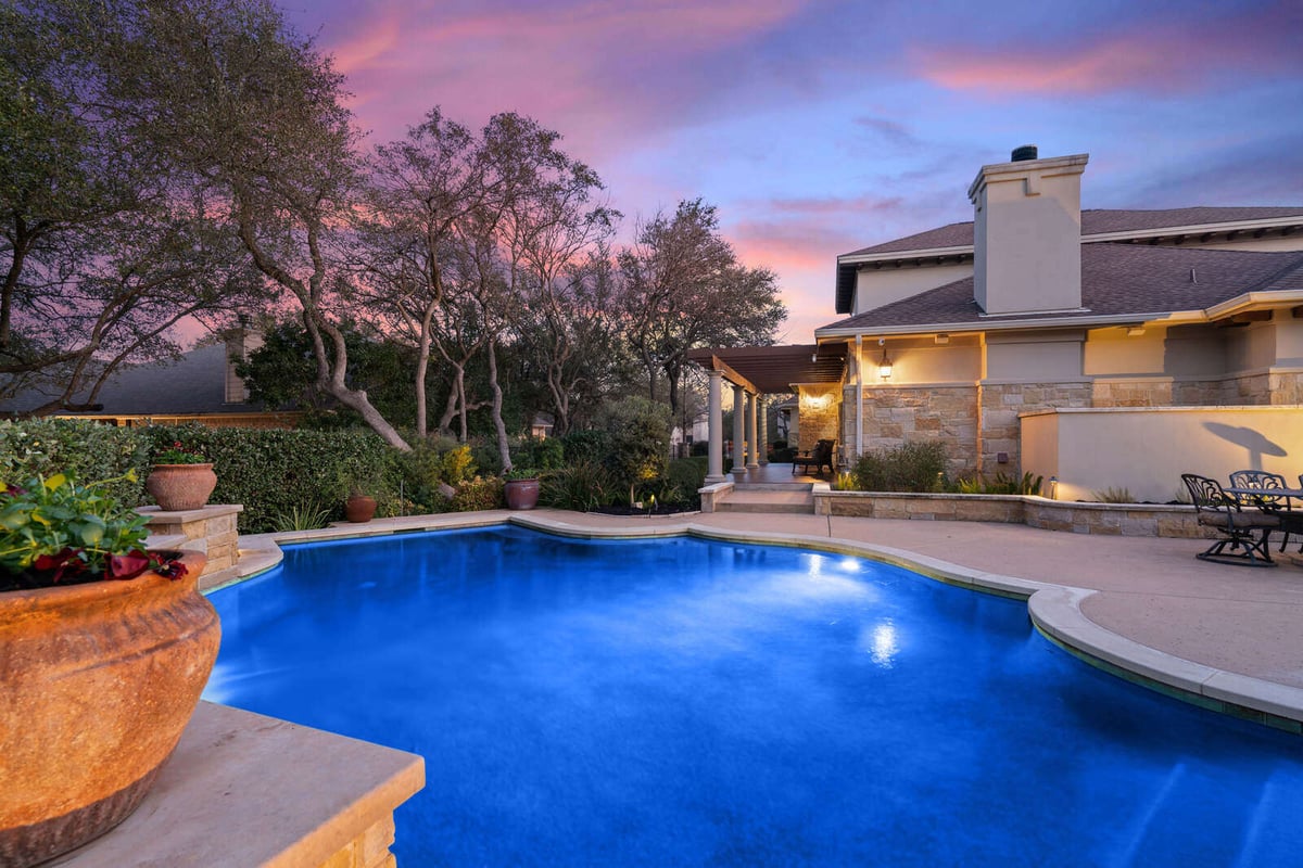 Custom home backyard pool glowing under a colorful evening sky by J Bryant Boyd, Georgetown, TX-1