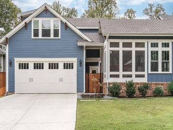 Image of a craftsman-style custom home in Georgetown, TX, with blue siding and white windows and doors. 