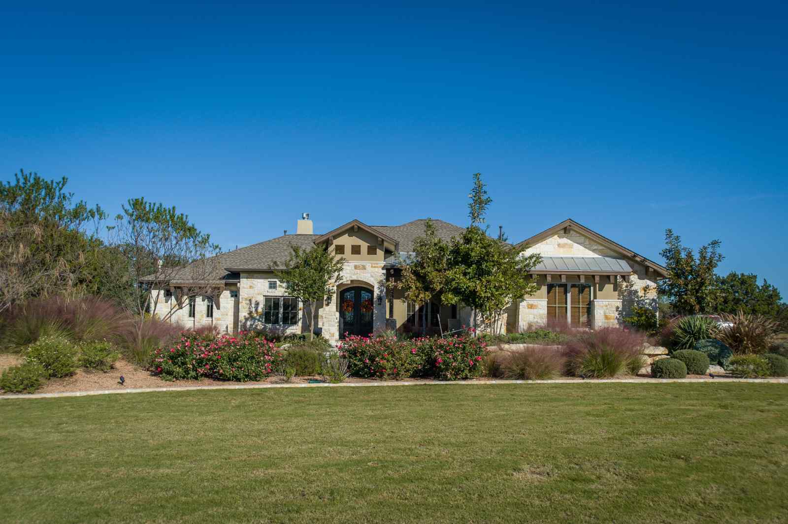 Front view of a beautifully landscaped custom home by J. Bryant Boyd in Central Texas Hill Country