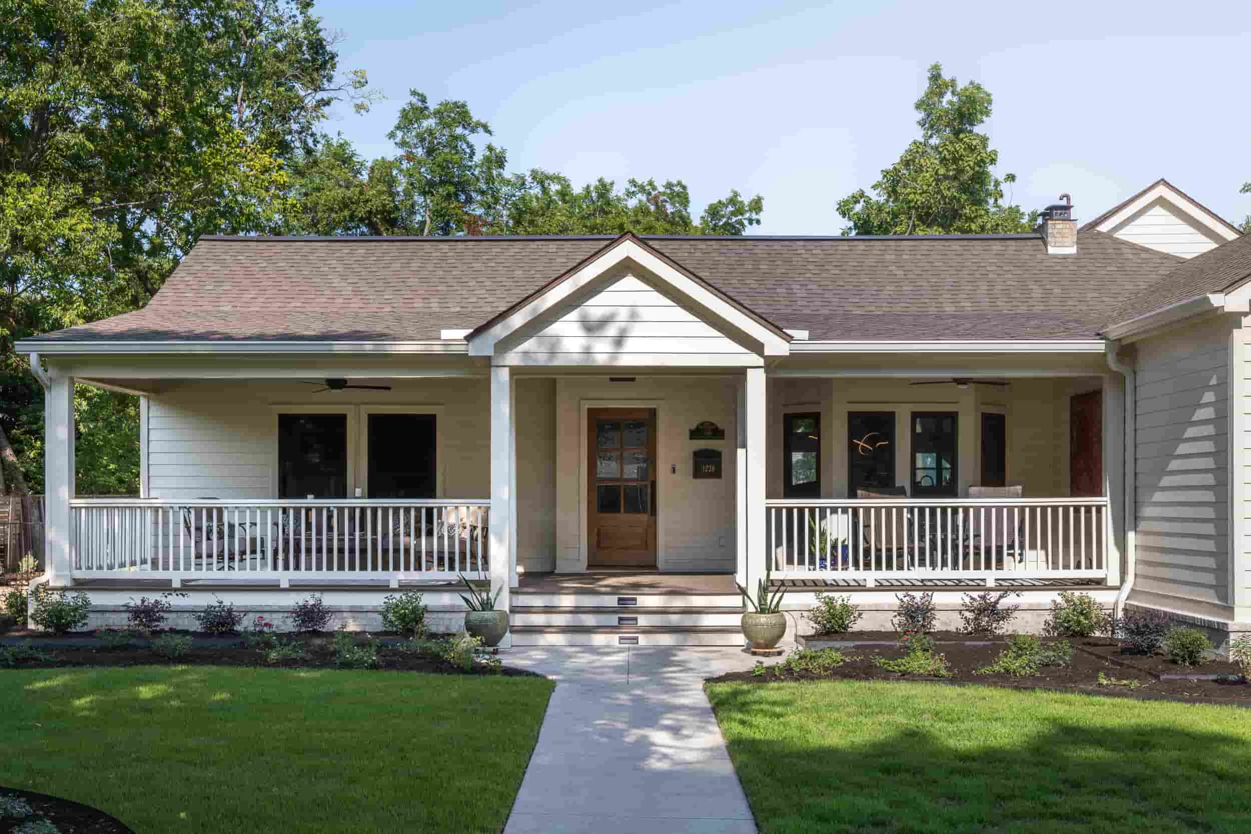 A charming Texas home featuring a welcoming front porch and a well-kept front yard, designed by J Bryant Boyd.